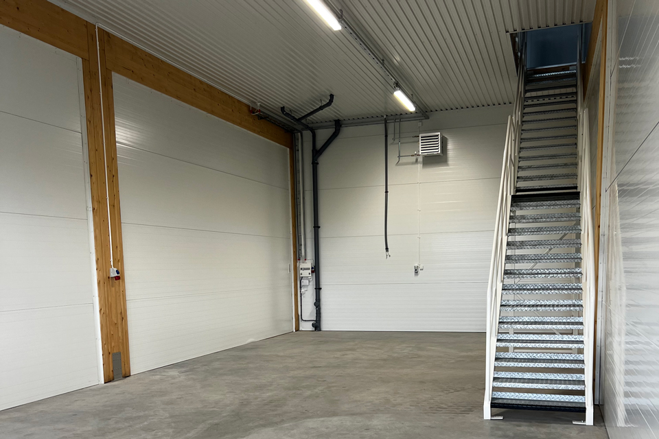Bild över en industribyggnad med flera stora blå dörrar - Ängamöllan företagspark.